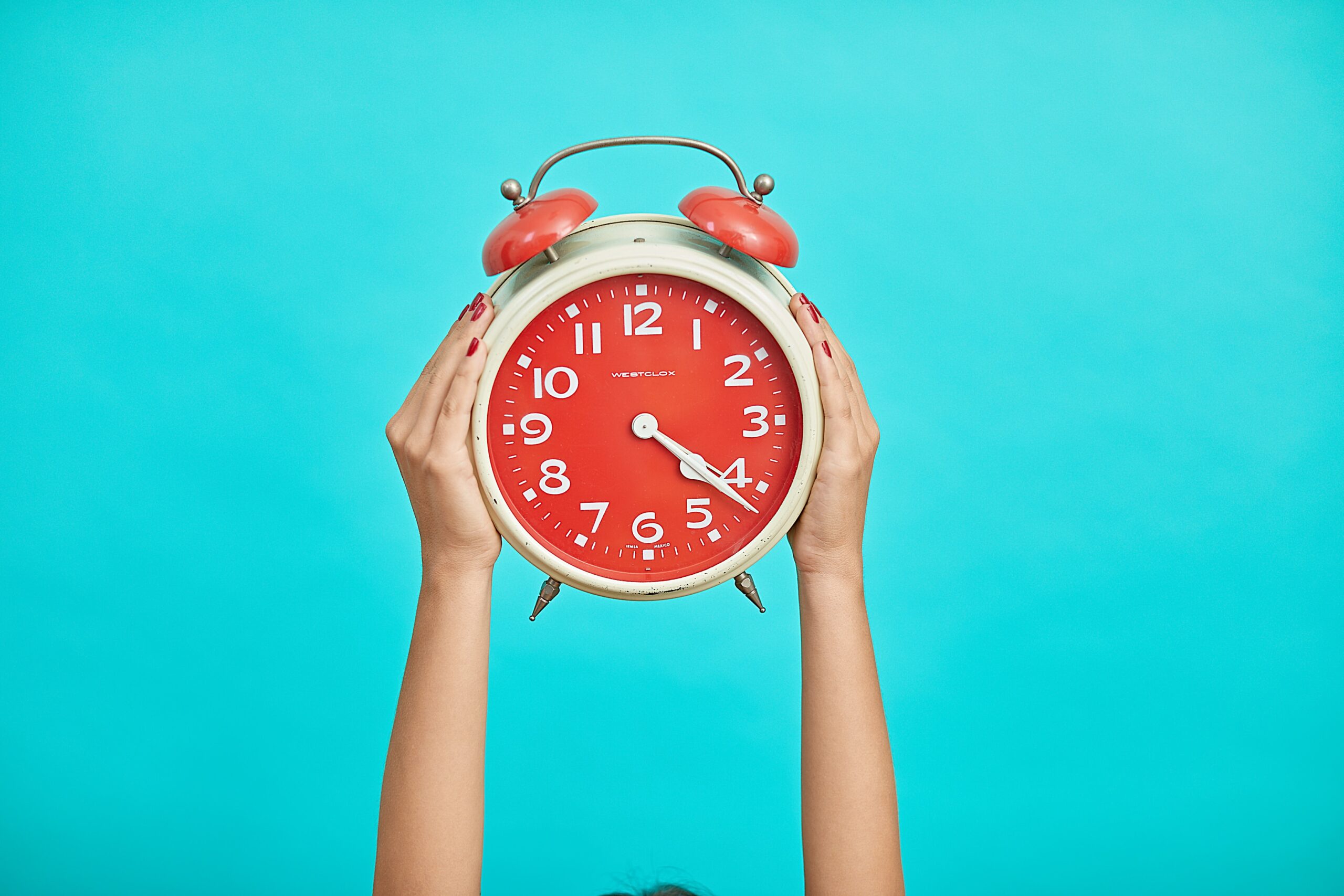 hands holding an alarm clock